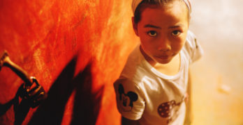 small child beside a red door