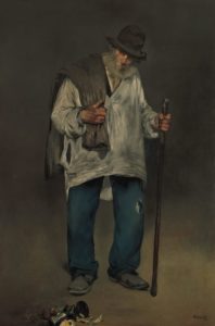 a man in raggedy clothes walks with a walking stick