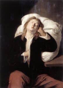 man sleeps sitting up with a pillow behind him
