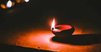 Lit diya lamp on street at night