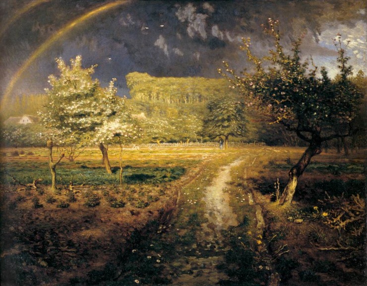 springtime light casts over a field that seems to have just been rained on as there are two rainbows