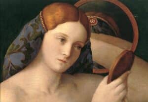 woman look into a mirror she is holding