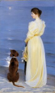 woman in a yellow dress and her dog by the sea