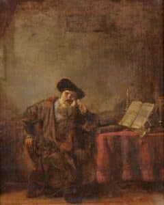man sits at study thinking