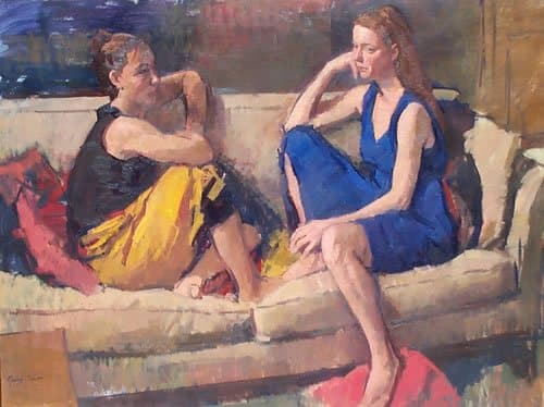two friends sit on a couch facing each other 