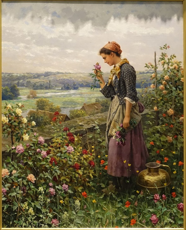 woman picking flowers by  fence 